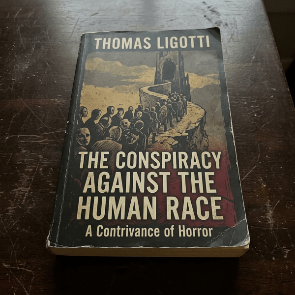 'The Conspiracy Against the Human Race' book cover by Thomas Ligotti showing a line of faceless figures walking towards a dark tower